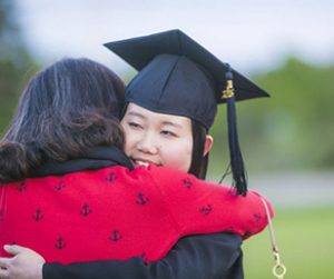 Student Graduating and being hugged.